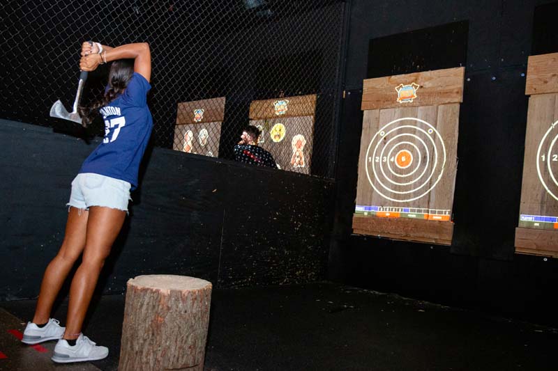 Girl throwing axe, bullseye. Montana Nights Top Axe-Bar + Entertainment Center in CT