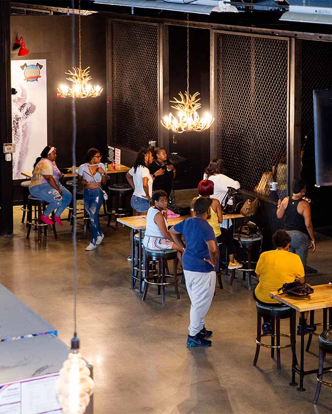 Restaurant section of axe throwing venue with customers sitting at high tables and watching other people throw axes. Montana Nights event space. Montana Nights Top Axe-Bar + Entertainment Center in CT