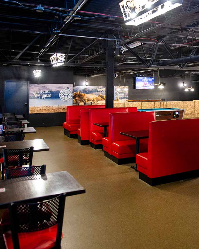 Red booths and small tables. Montana Nights event space. Montana Nights Top Axe-Bar + Entertainment Center in CT