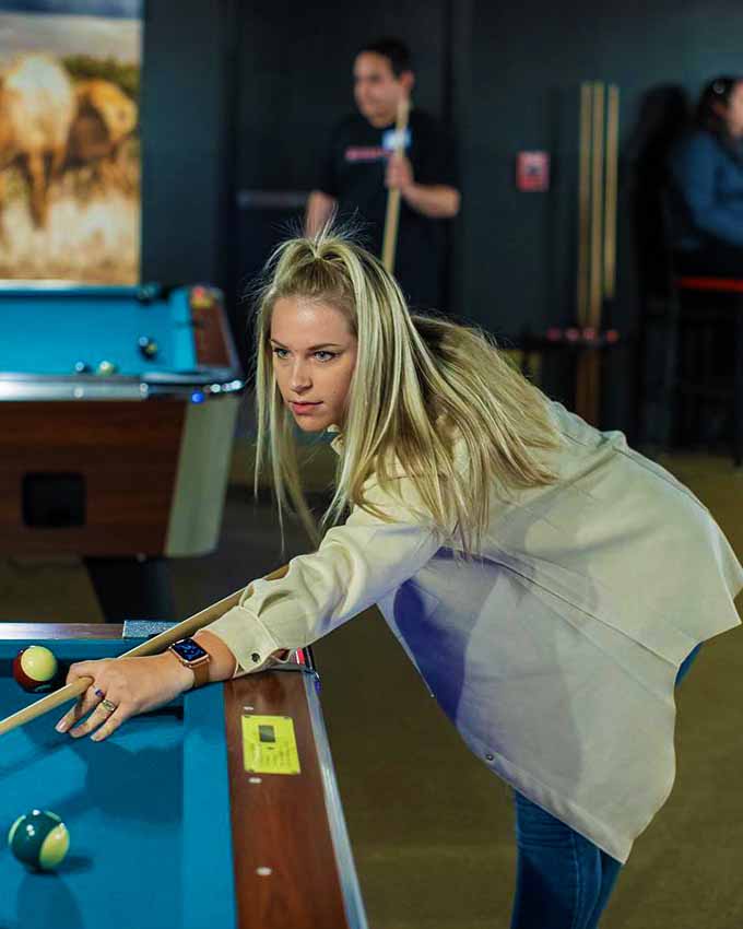 Woman playing pool. Montana Nights event space. Montana Nights Top Axe-Bar + Entertainment Center in CT