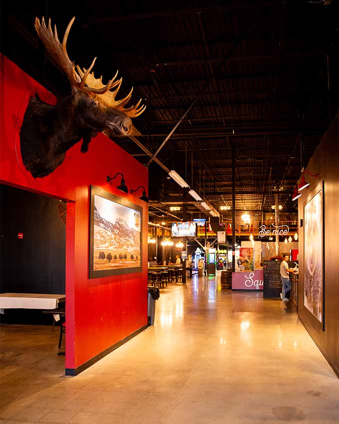 Mounted head of a moose and other artwork in a large hallway. Montana Nights event space. Montana Nights Top Axe-Bar + Entertainment Center in CT