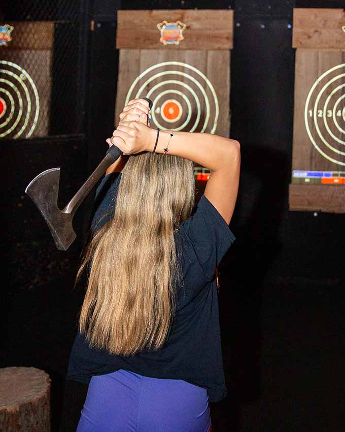 Back shot of woman preparing to throw an axe. Montana Nights event space. Montana Nights Top Axe-Bar + Entertainment Center in CT