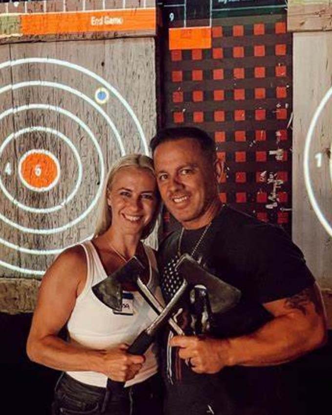 Happy couple smiling holding axes at Montana Nights Top Axe-Bar + Entertainment Center in CT