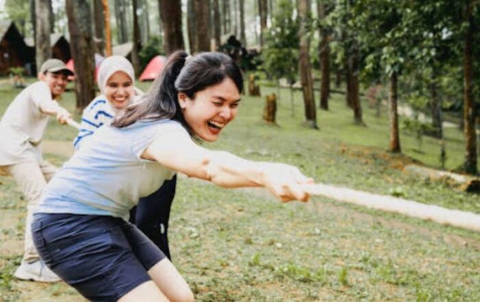 Employees enjoying tug of war outside the office