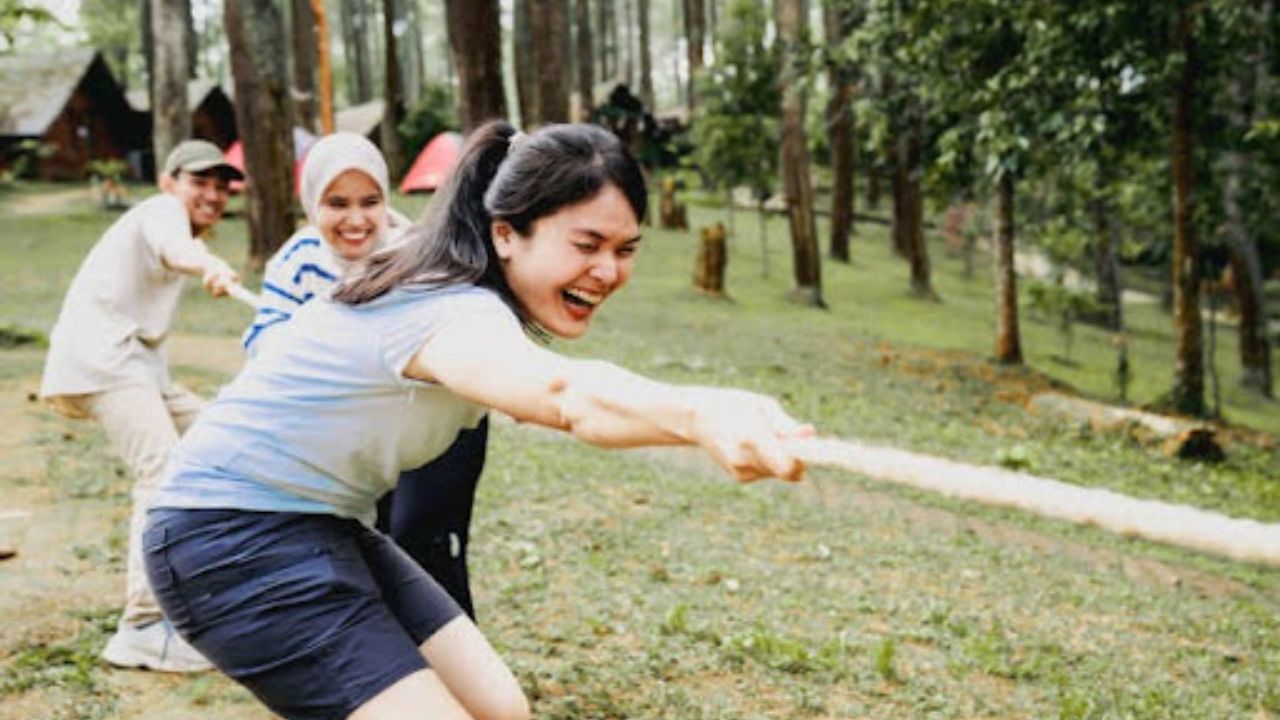Employees enjoying tug of war outside the office