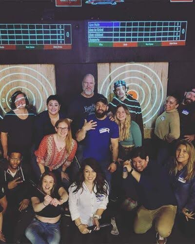 Employees posing for picture at an axethrowing venue