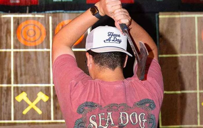 A man preparing himself to throw the axe at the target.