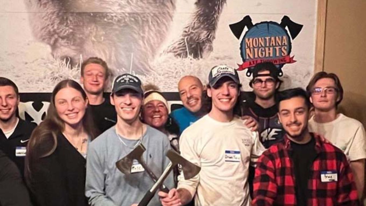 Group of adults posing together at Montana Nights Axe Throwing.