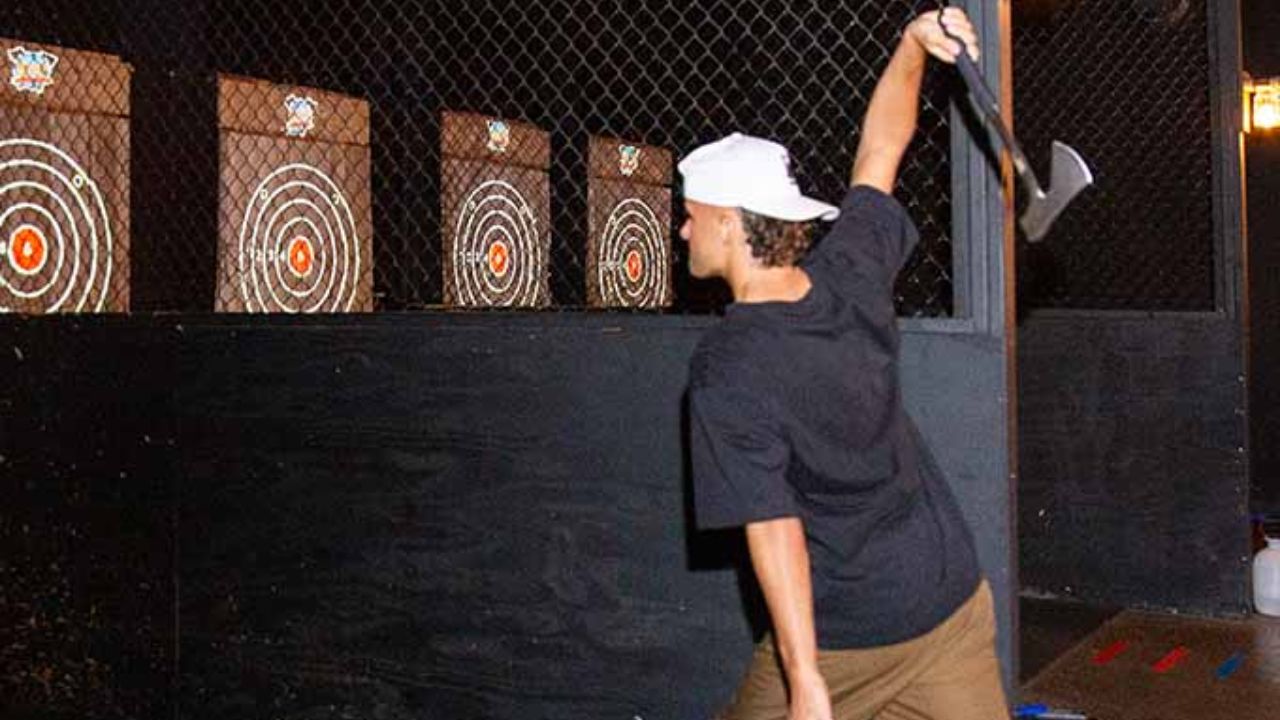 Axe throwing participant aiming at a target inside a throwing lane.