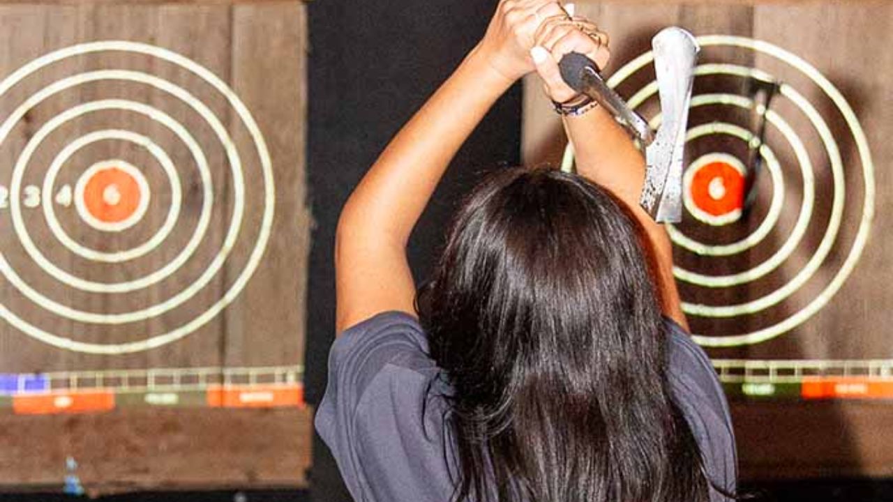 Woman aiming at wooden targets with red bullseyes at Montana Nights
