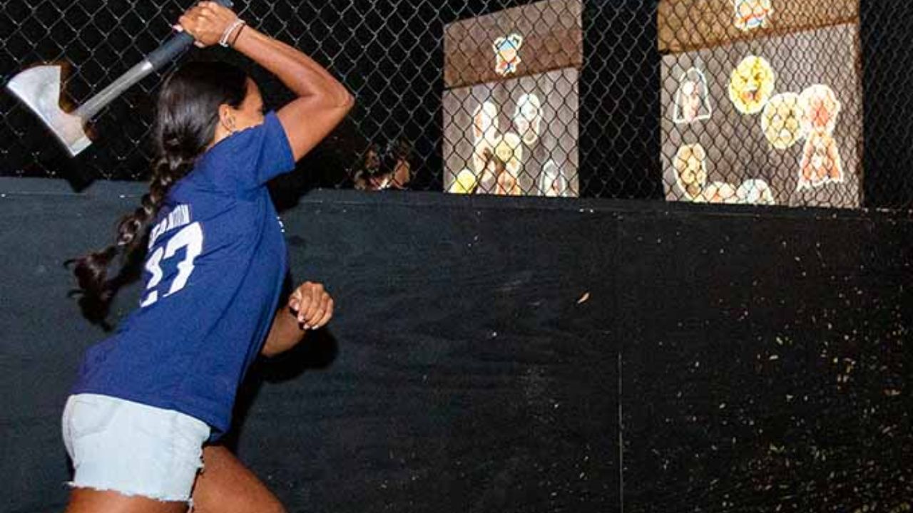 A player preparing to throw an axe at an interactive digital target.
