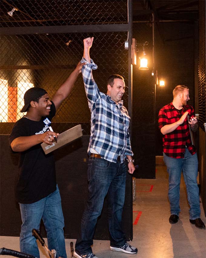 Friends celebrating after an axe throwing game inside Montana Nights. 