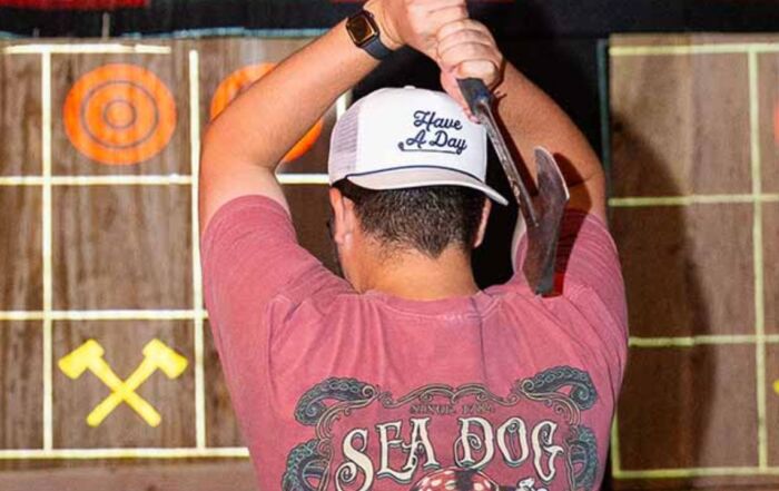 Man preparing to throw axe at target at Montana Nights.