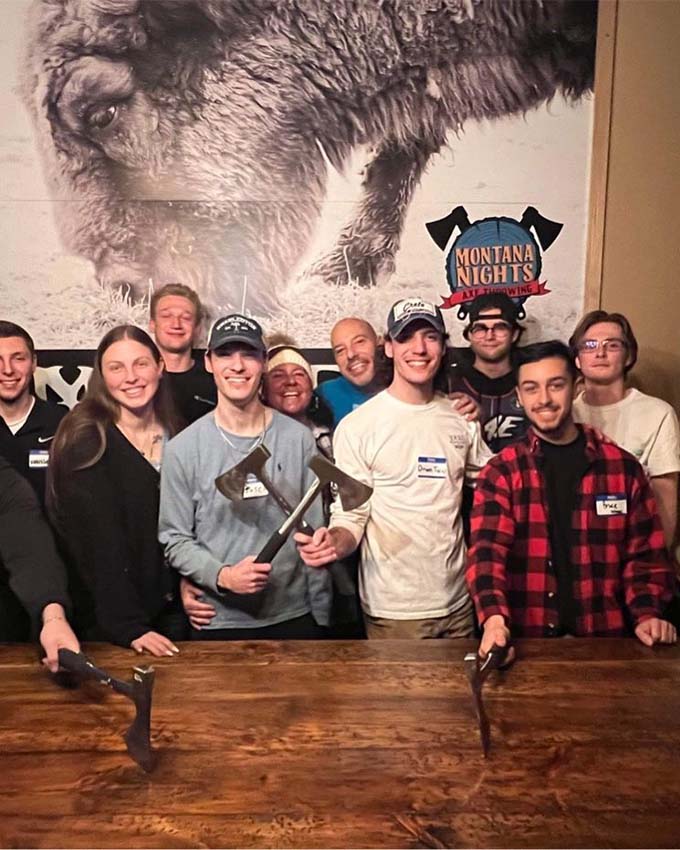 Adults enjoying social activity with axes at Montana Nights