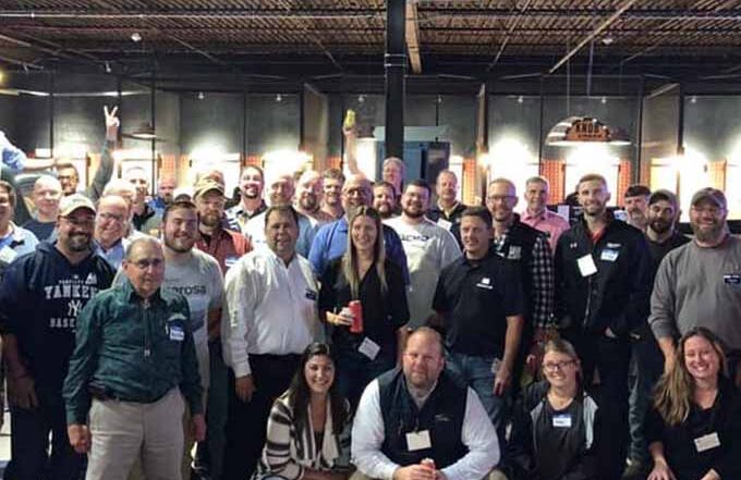 Large group of adults at team outing in axe throwing facility