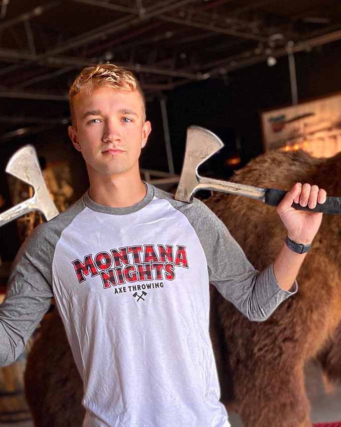 Montana Nights axe throwing participant holding axes at venue