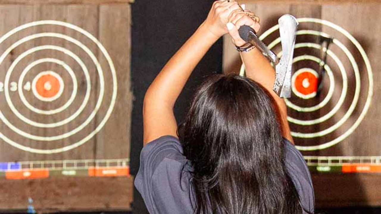 Axe throwing player aiming at target board indoors