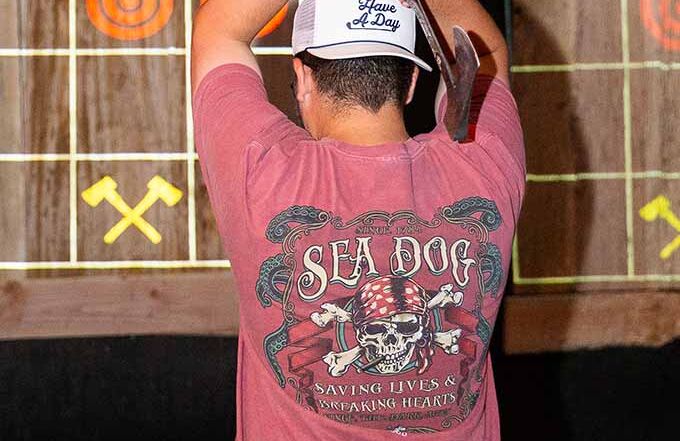 Indoor axe throwing game with projected targets and score display at Montana Nights