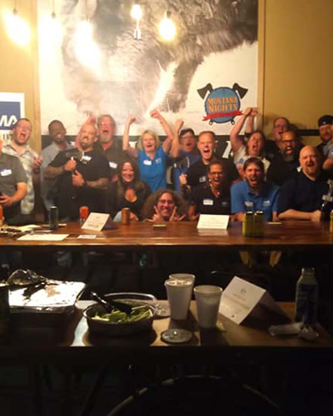 Group photo capturing a successful charity event at an axe throwing venue