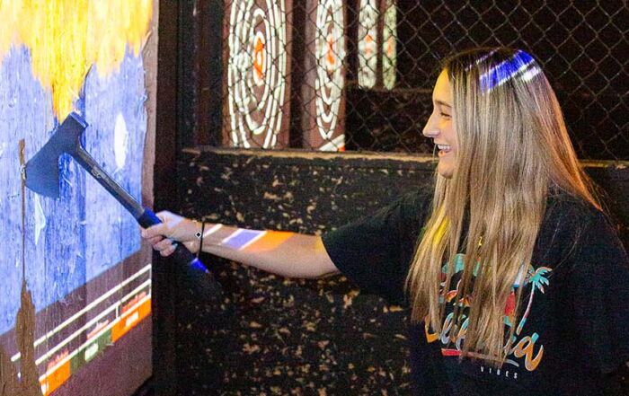 Guests enjoying an immersive axe throwing game with dynamic digital targets and scoring.