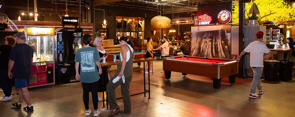 Guests relaxing with pool tables, arcade games, and lounge seating at Montana Nights Axe Throwing.