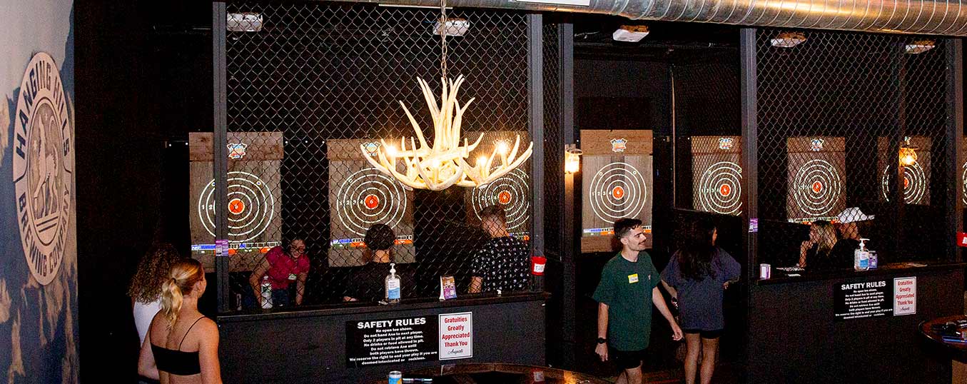 Spacious entertainment area featuring multiple axe lanes and rustic decor.