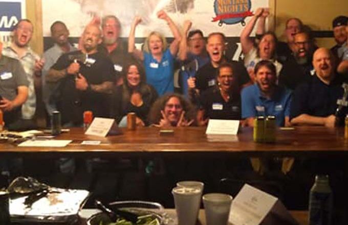 Corporate team celebrating during a private axe throwing event with food and group activities at Montana Nights.