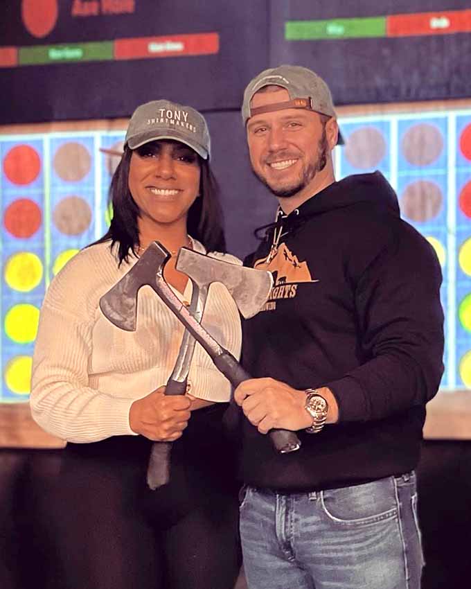 Couple smiling and holding axes after enjoying an axe throwing experience at Montana Nights.