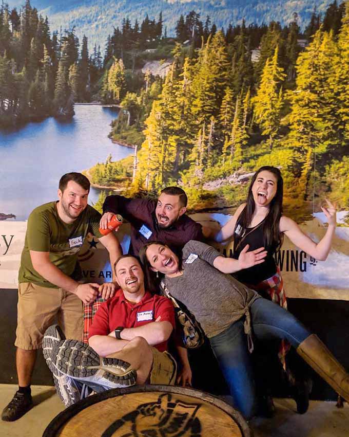 Group of friends laughing and posing together after an axe throwing experience at Montana Nights.