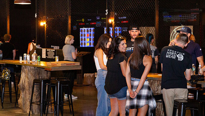 Guests socializing and enjoying axe throwing lanes at Montana Nights Axe Throwing.