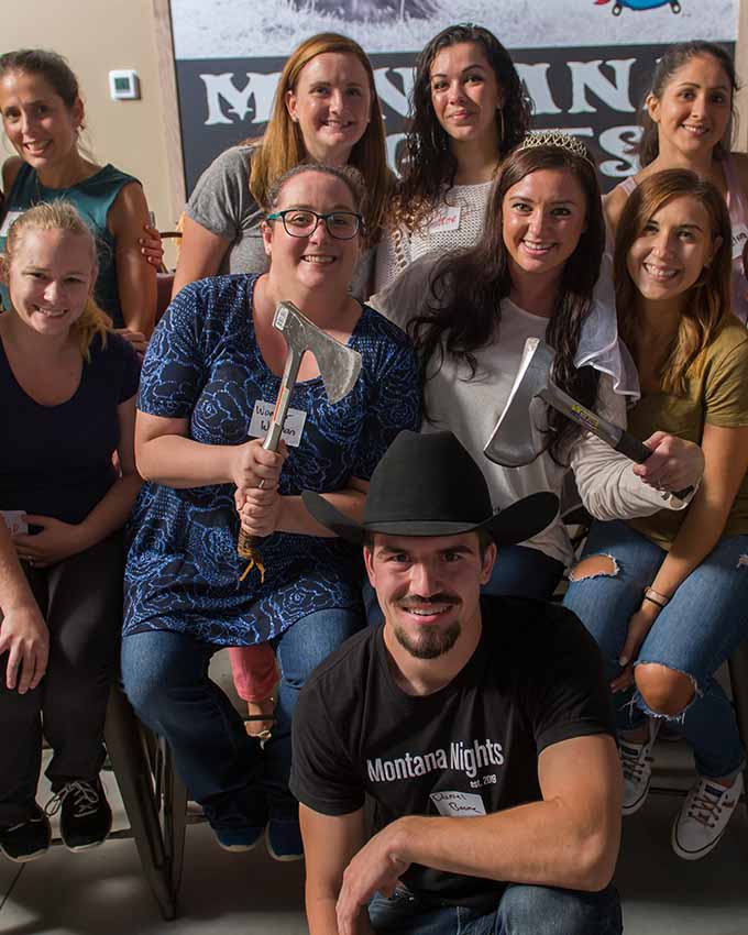 Group posing with axes at a group event in Montana Nights.