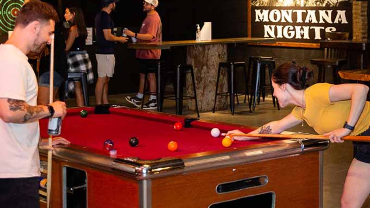 Guests playing pool and socializing at Montana Nights.