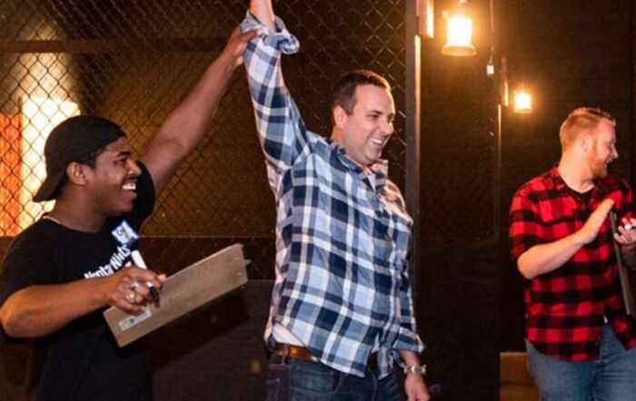 Friends celebrating a successful axe throw during a group event.