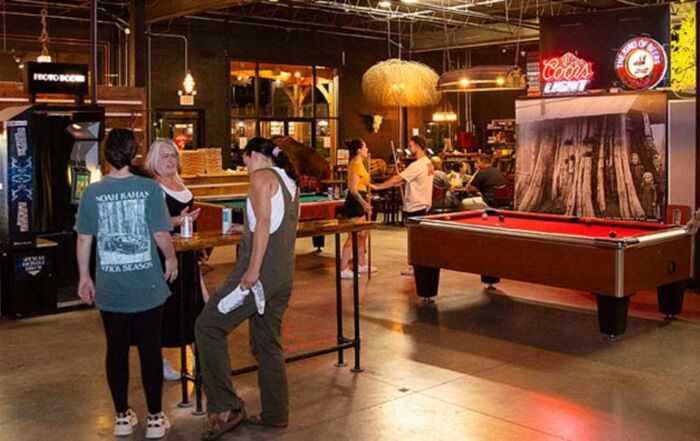 Guests enjoying arcade games, pool tables, and social activities indoors at Montana Nights.