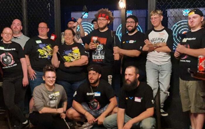 Group enjoying a fun team-building event at an indoor axe throwing venue.
